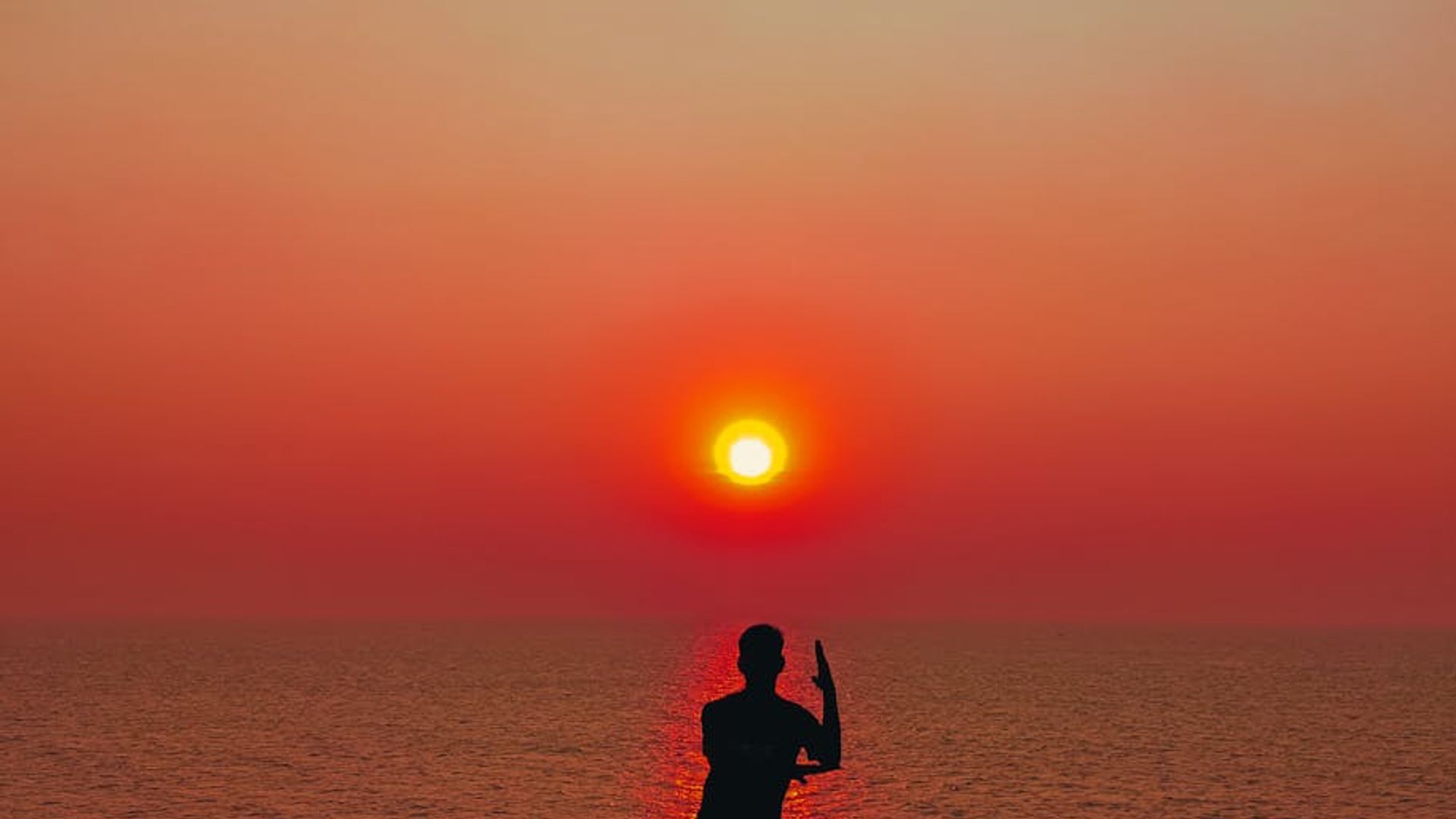 Calm silhouette of a person practicing yoga at dusk.